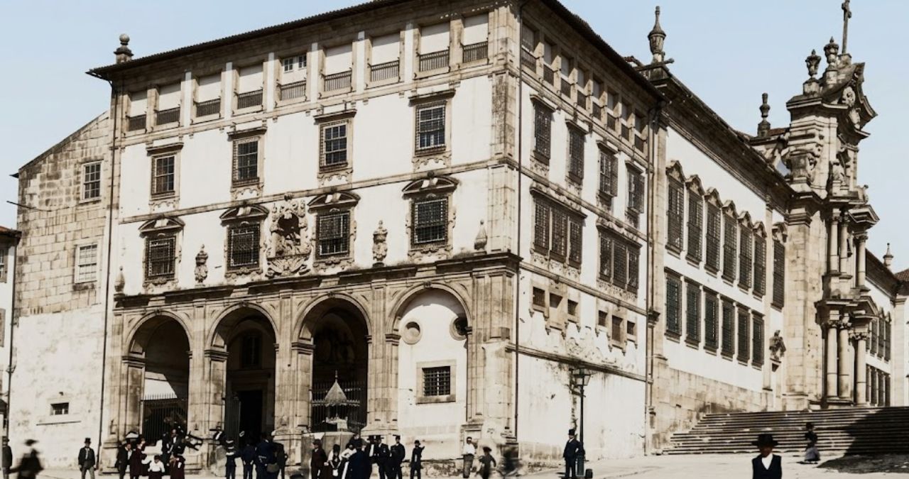 Fachada histórica do Mosteiro de São Bento da Avé-Maria com arquitetura monumental em pedra, janelas alinhadas, arcadas na entrada e pessoas circulando na área externa.