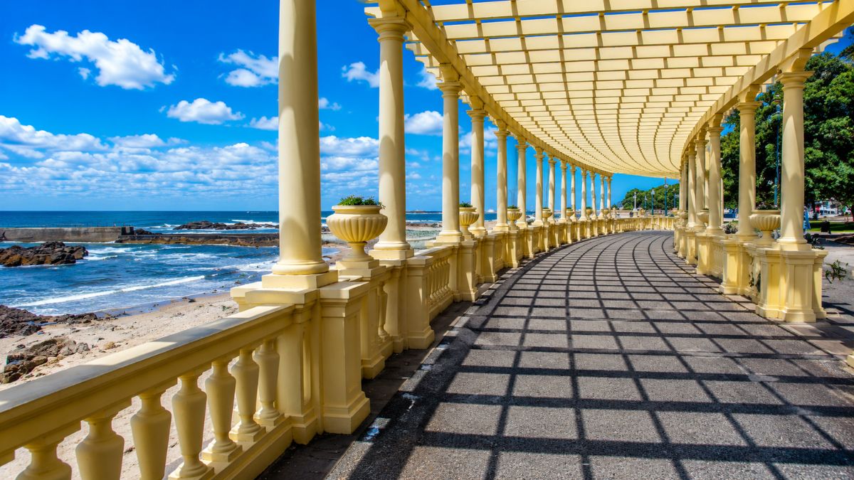 Estrutura amarela da Pérgola da Foz com colunas neoclássicas localizada na avenida beira-mar ao lado do Oceano Atlântico no Porto