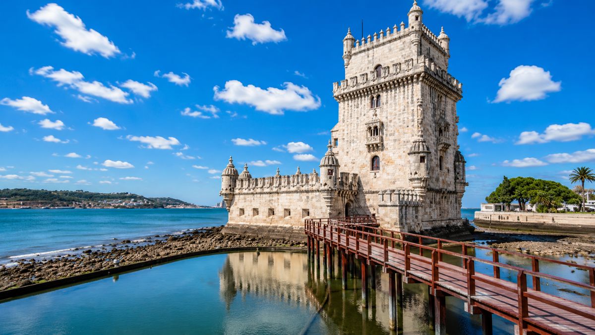 Torre de Belém com passarela de madeira sobre o Rio Tejo em um dia ensolarado de verão em Lisboa Portugal.