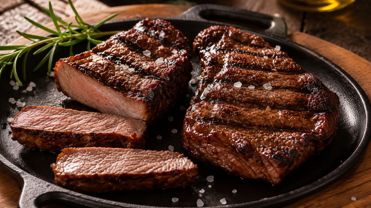 Chapa de ferro com suculentos bifes de carne de boi grelhados, salpicados com sal grosso e decorados com alecrim fresco.