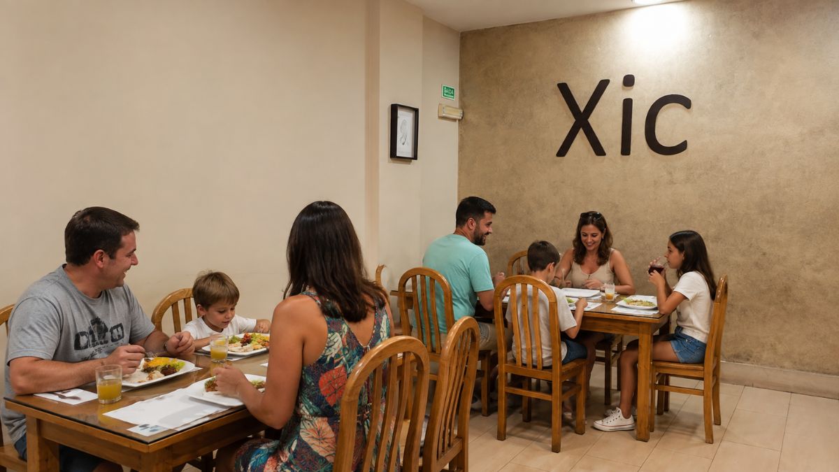 Famílias almoçando em mesas de madeira no salão do Restaurante Xic com letreiro na parede em Faro.
