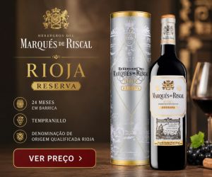 Anúncio publicitário do vinho tinto Marqués de Riscal Reserva Rioja, mostrando a garrafa ao lado de seu estojo metálico cinza e dourado. À esquerda, textos técnicos informam 24 meses em barrica, uva Tempranillo e Denominação de Origem Qualificada Rioja, com um botão vermelho escrito "Ver Preço". Uma taça de vinho e uvas decoram o fundo à direita.