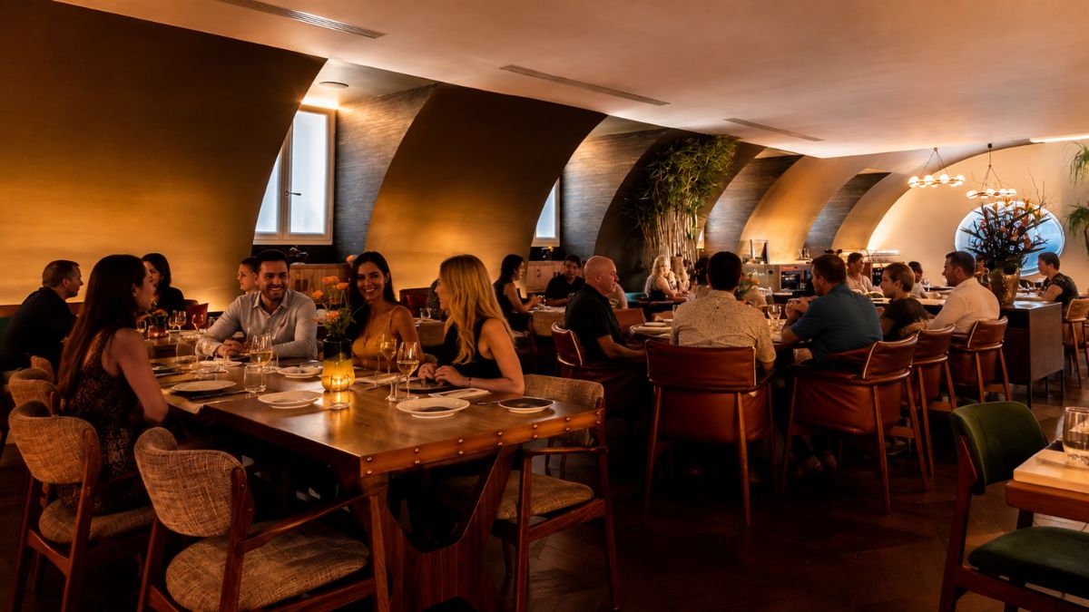 Pessoas jantando em salão sofisticado de restaurante aconchegante no Bairro Alto em Lisboa com iluminação acolhedora e decoração elegante.