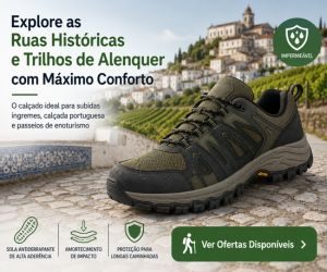 Sapatilha impermeável de caminhada em tom verde militar com sola antiderrapante disposta sobre calçada portuguesa com paisagem urbana histórica ao fundo.